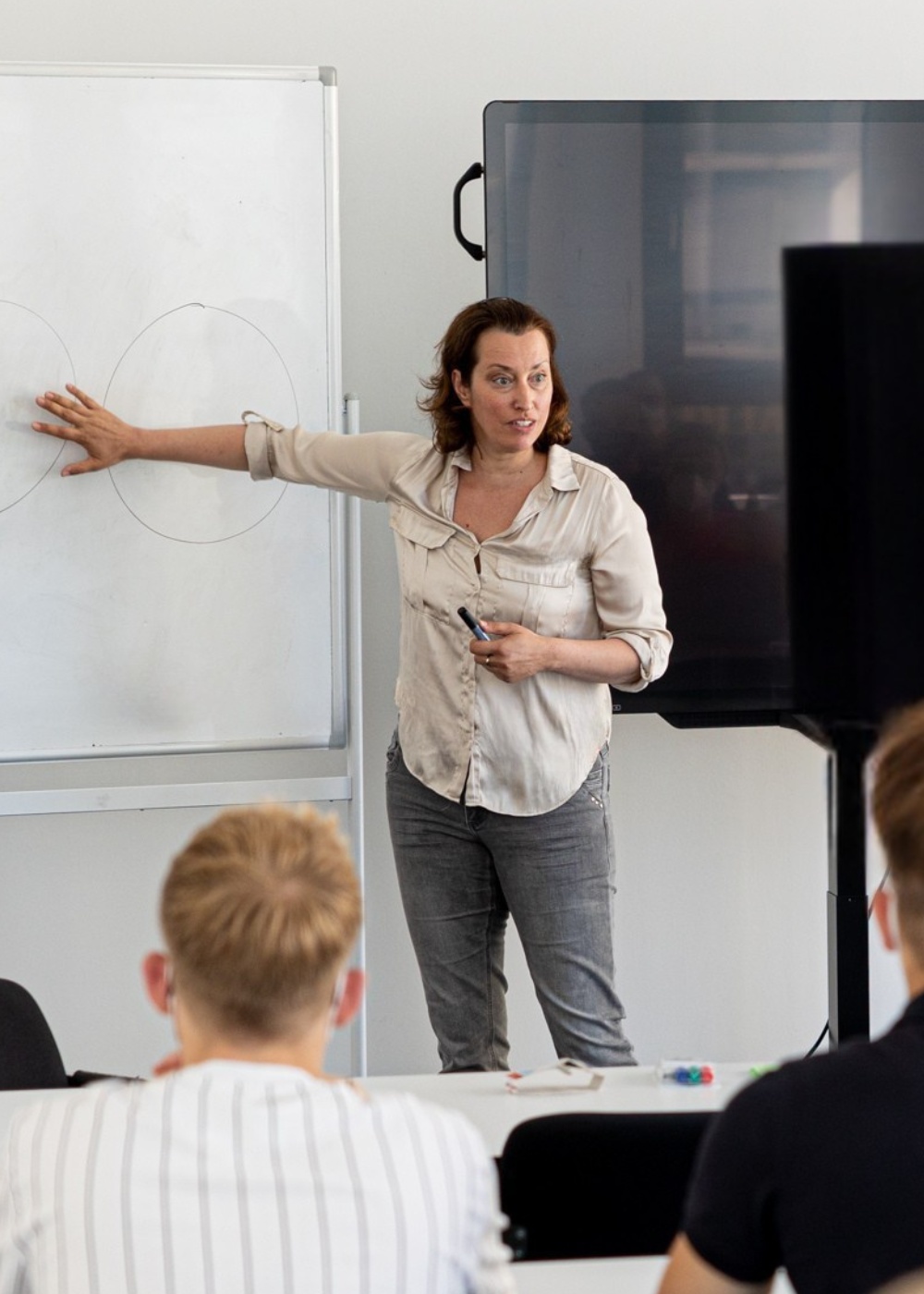 Dr. Julia Staffa erklärt agile Coaching-Strategien am Whiteboard in einem interaktiven Workshop mit Teilnehmenden. 